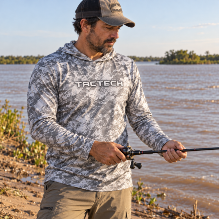 Pescador usando la remera TACTECH con capucha en Gris original junto al río Paraná
